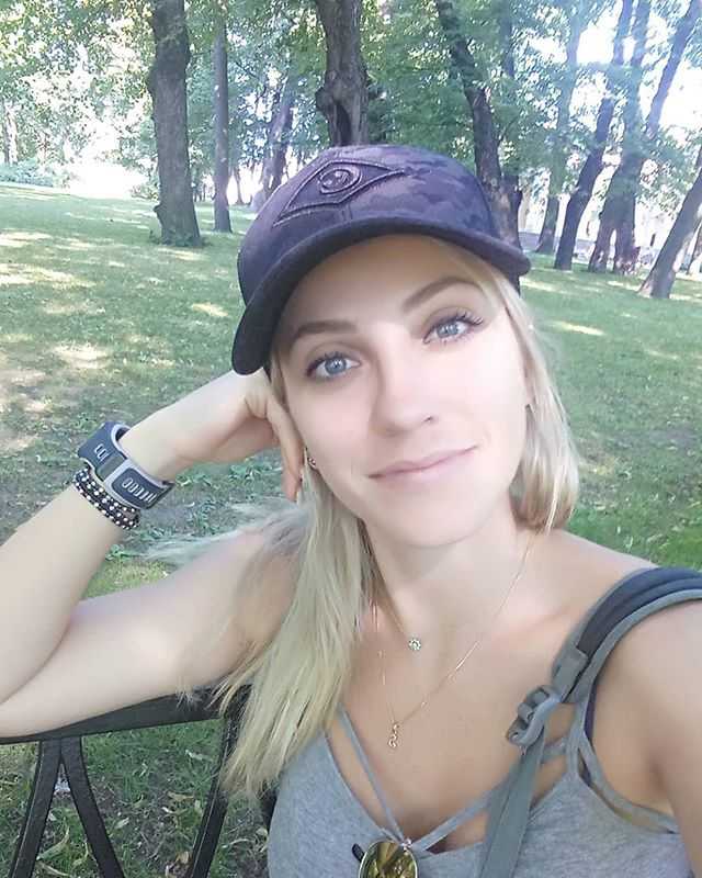 费尔南达身穿休闲装束在球场边回眸一笑，金发在阳光下闪耀，气质超凡脱俗