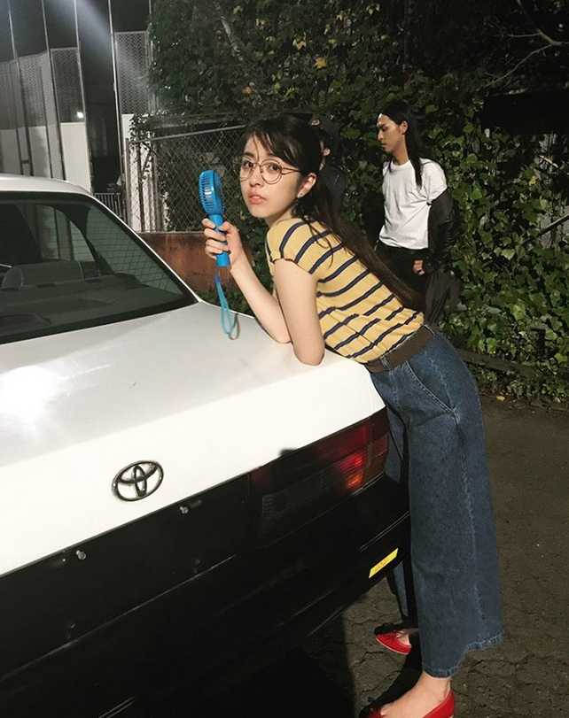 柳百合菜身材高挑，在简单背景的映衬下，其优越的身体线条和时尚感展露无遗，不愧是时尚界的宠儿。