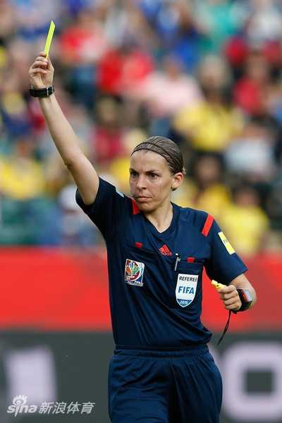 弗拉帕特手持法甲比赛用球步入球场，脸上带着谦逊而自信的微笑，阳光洒在她身上，映照出一位开拓者从容不迫的身影与坚定的步伐
