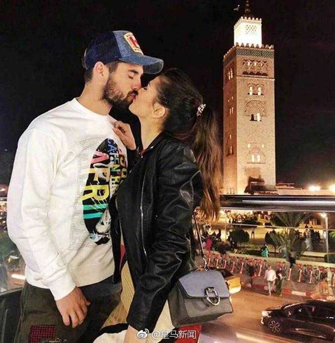 伊斯科和女友莎拉参加好友聚会，两人身穿情侣色系的服装，伊斯科搂着莎拉的肩膀，亲密无间，时尚感十足