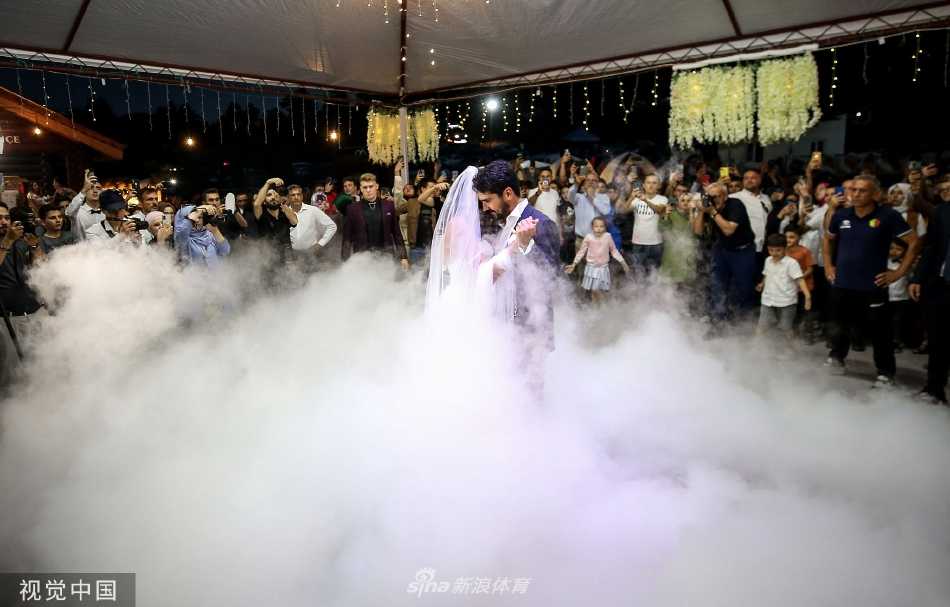 京多安身着经典黑色礼服，与一袭圣洁白纱的妻子在仪式上共同切下多层婚礼蛋糕，寓意着共同开启甜蜜的新生活。