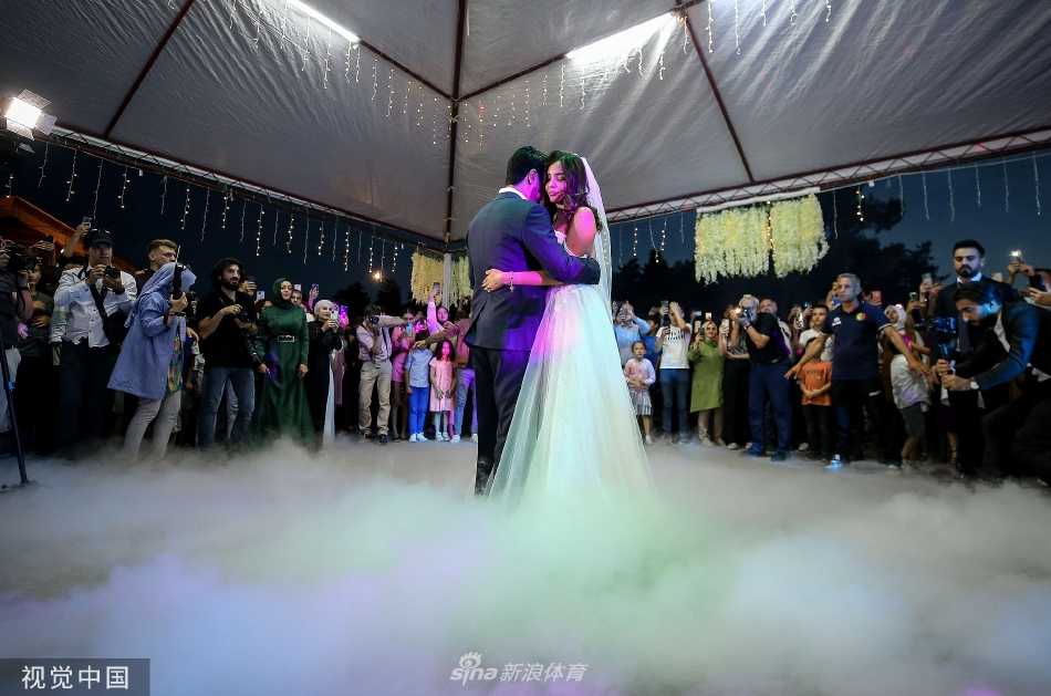 京多安温柔地搂着妻子的腰，两人在装饰精美的婚礼场地中央翩翩起舞，灯光洒落，宛如童话中的王子和公主。
