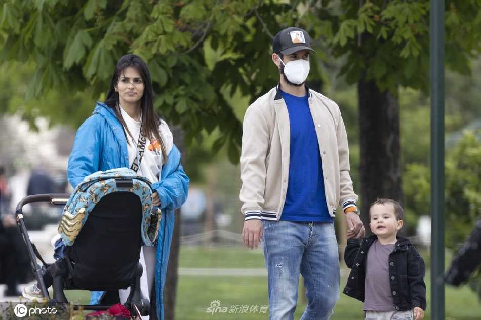 伊斯科弯腰轻握儿子小手，阳光将父子相依的身影拉长，孩童兴奋地迈出稚嫩步伐