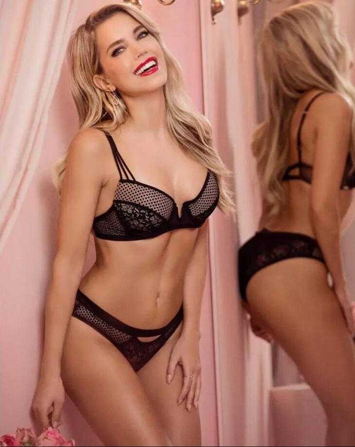轻柔的光线勾勒出她精致的锁骨线条，精巧的蕾丝纹样如同第二层肌肤般贴合。她微微侧首，那一抹不经意间流露的笑意，糅合了少女的娇羞与成熟女性的慵懒风情，定格成一幅流动的画。
