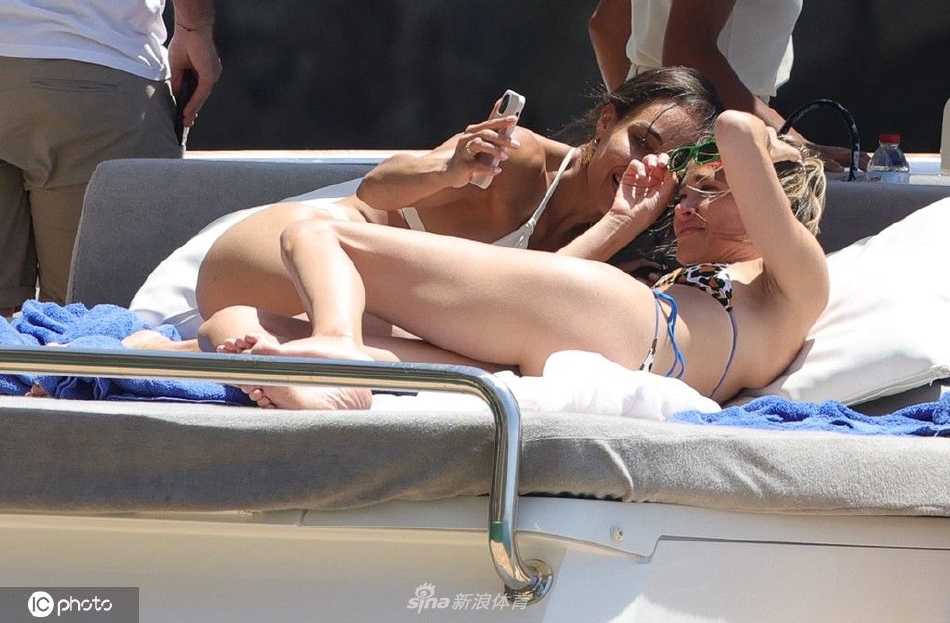 蔚蓝的海面上，游艇划出优雅的白色航迹，背景是伊维萨岛起伏的绿色海岸线与澄净天空。