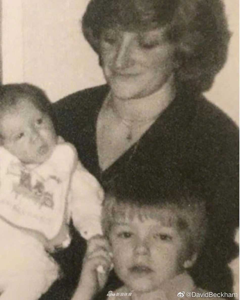 年幼的贝克汉姆依偎在年轻美丽的母亲桑德拉怀中，母亲怀抱襁褓中的妹妹，画面洋溢着温馨与慈爱。