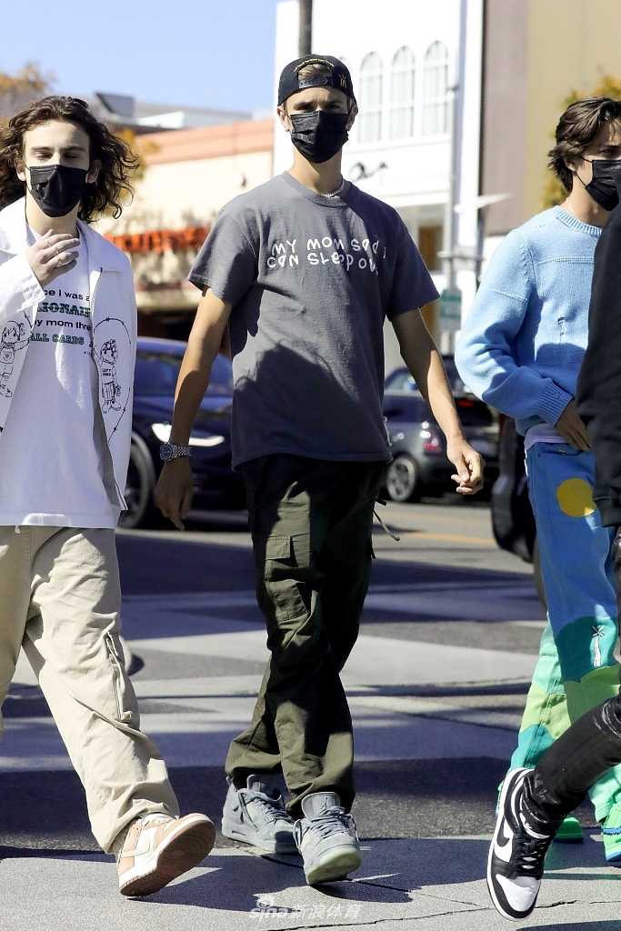 保镖为罗密欧留意着路况，罗密欧则专注于手中的物品，短袖的衣袖被微风轻轻吹起，这一瞬间的动态抓拍充满了生活气息。