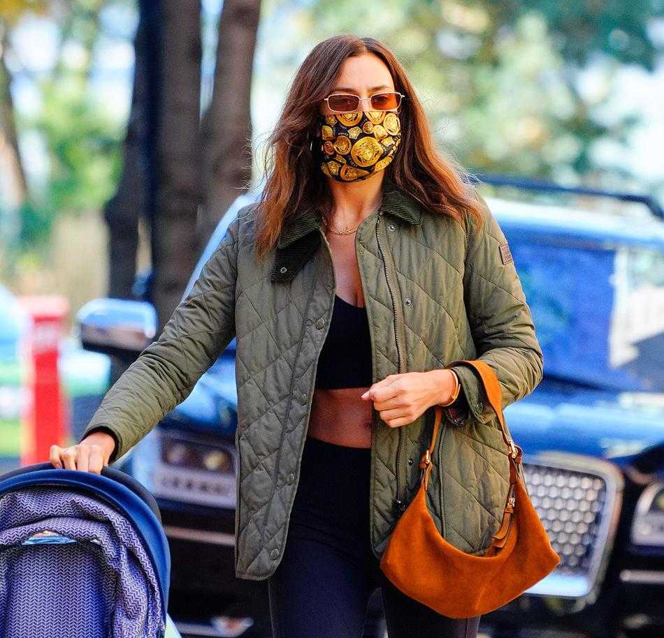 过马路时，伊莲娜一边谨慎地观察路况，一边用身体护住婴儿车，女儿则安心地坐在车内，似乎早已习惯妈妈这样无微不至的守护，母女间无声的默契与依赖在川流不息的街头显得格外温馨。