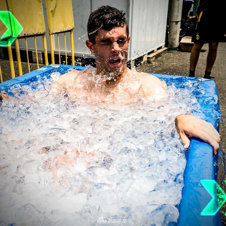 科技感十足的液氮冷冻治疗舱矗立在训练房一角，舱体线条流畅，金属光泽与周围的冷光相映，背景中是正在训练的模糊身影，展现了运动与科技的完美融合。